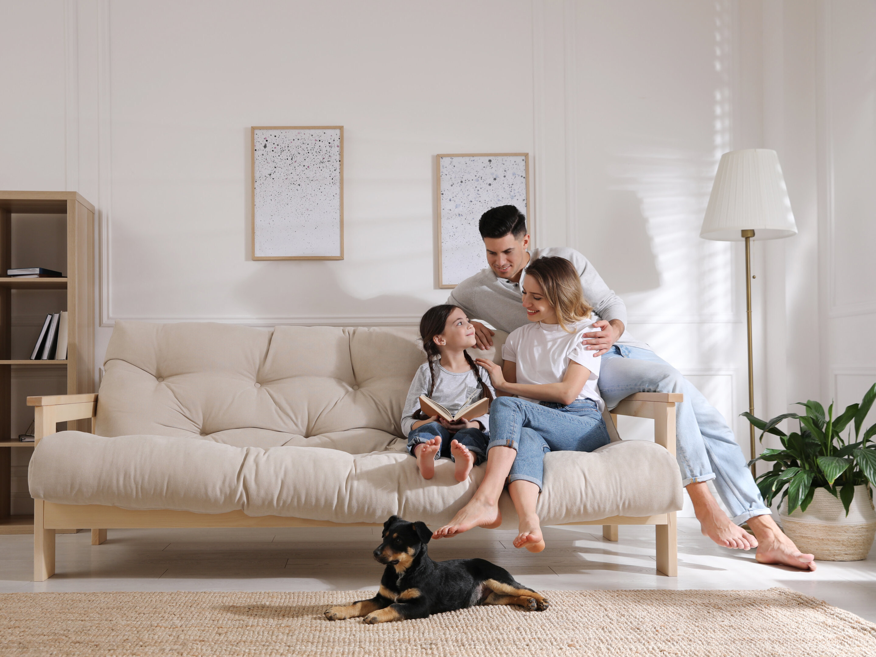 Happy family on sofa and puppy in living room